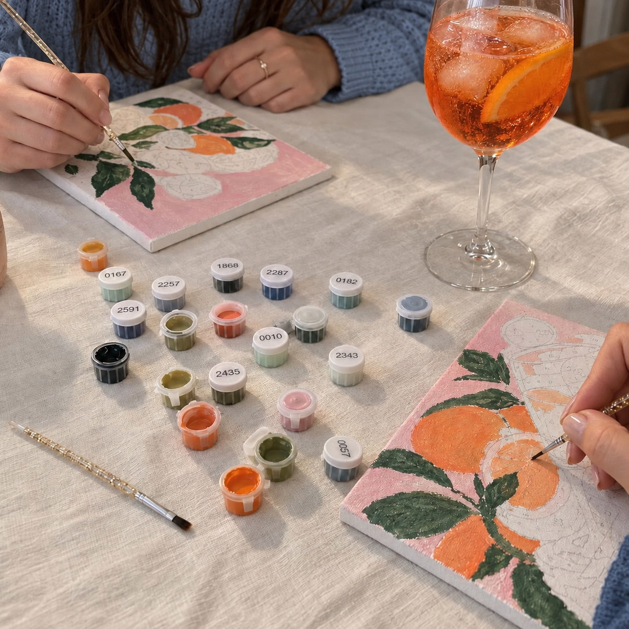 Pinsel, Farbtöpfchen und ein Bild mit Orangen